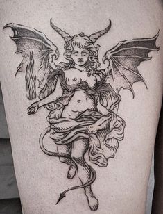 a woman with an angel tattoo on her thigh, holding a dragon and sitting on the ground