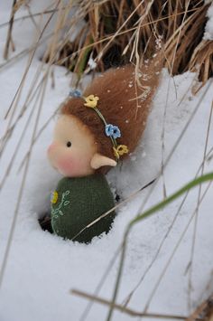 a small doll is sitting in the snow