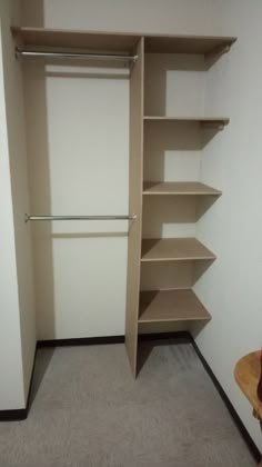 an empty walk in closet with shelves and clothes rails