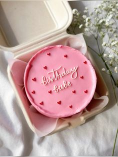 a pink birthday cake in a box with the words happy birthday babe written on it