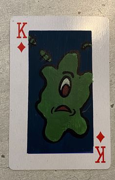 a playing card with an image of a green monster