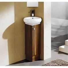 a bathroom sink sitting next to a wall mounted faucet with a wooden cabinet underneath it