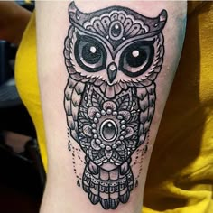 an owl tattoo on the arm