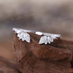 a close up view of a diamond ring on top of a piece of wood,