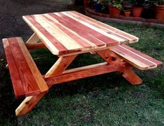 a wooden picnic table sitting in the grass