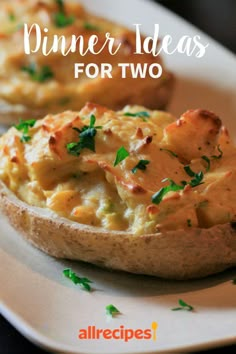 two baked potatoes on a white plate with parsley