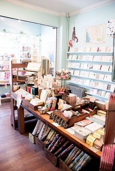 a book store filled with lots of books on top of wooden shelves next to a window