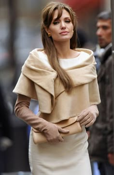 a woman in a dress and gloves on the street