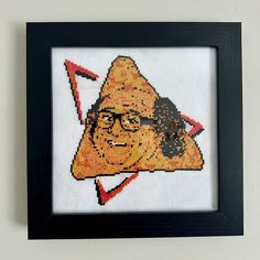 a cross - stitch picture of a man with glasses and a triangle on his head