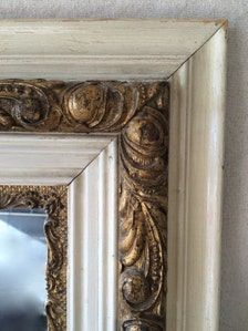 an ornate gold framed mirror on the wall