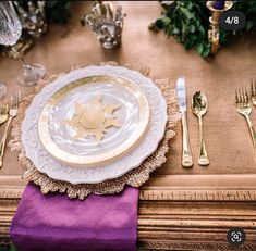 a place setting with gold and purple napkins