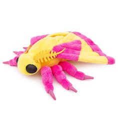 a pink and yellow stuffed animal laying on top of a white surface