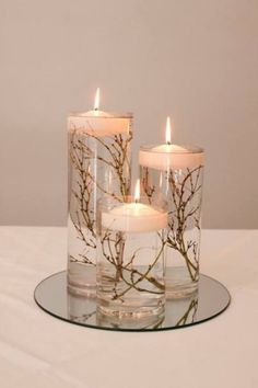 three candles sitting on top of a glass plate