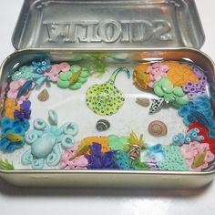 there is a tin with some sea life on it and the lid has buttons in it