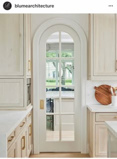 an open door leading to a kitchen with wooden cabinets and white counter tops on both sides