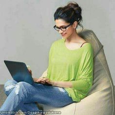 a woman sitting on a bean bag chair using her laptop