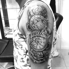 a black and white photo of a man's arm with a clock tattoo on it