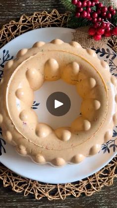 a cake sitting on top of a white plate next to a christmas wreath and red berries