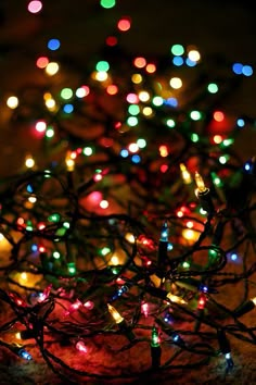 a bunch of christmas lights that are on the ground in front of a tablecloth