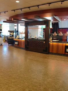 the inside of a restaurant with tables and counter tops, lights hanging from the ceiling