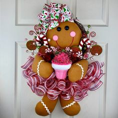 a door hanger with a teddy bear holding a cupcake and candy canes