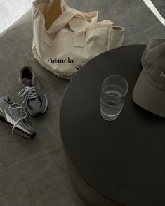 a pair of shoes and a tote bag sitting on the ground next to a table