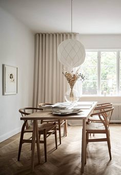 a dining room table and chairs in front of a window