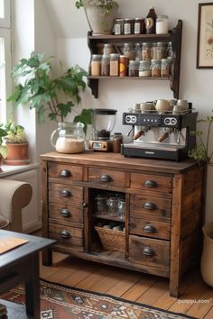 an old fashioned coffee maker on top of a wooden cabinet in a room with potted plants