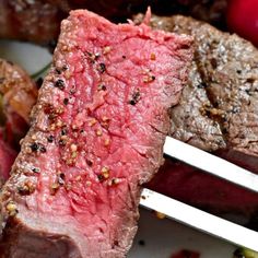 a piece of steak on a plate with two forks