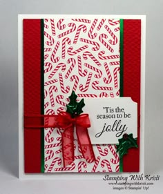 a handmade christmas card with red and green ribbons, holly leaves and a white tag that says tis the season to be jollyly