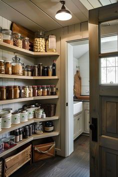 an open pantry with lots of jars and containers on the shelves next to a door