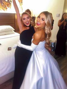 two beautiful women in dresses standing next to each other