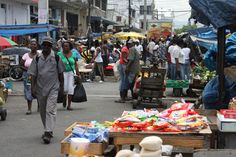 people are walking through an open air market