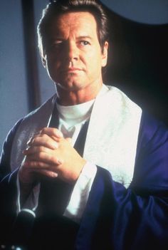 a man wearing a robe and holding his hands together