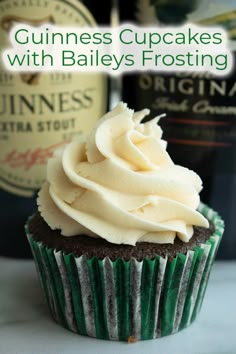 cupcakes with bailey's frosting are sitting next to a bottle of booze