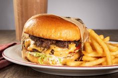 a cheeseburger and fries on a plate with a drink