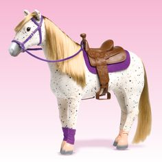 a toy horse with blonde hair and purple boots on it's head, standing in front of a pink background