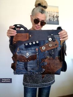 a woman holding up a purse made from old jeans