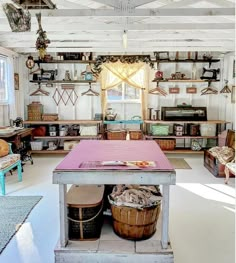 a room filled with lots of furniture and baskets on top of the table in front of a window