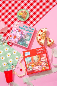 an assortment of items on a pink background including cake, magazine and cupcakes