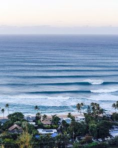 an ocean view with houses and trees in the foreground