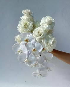 a hand holding a bouquet of white flowers