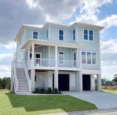 a two story house with white balconies and blue doors on the second floor