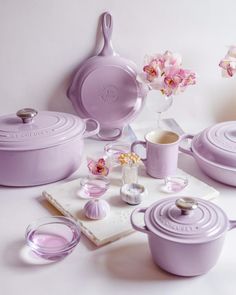 purple pots and pans are sitting on a table