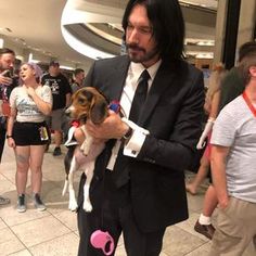 a man in a suit holding a small dog