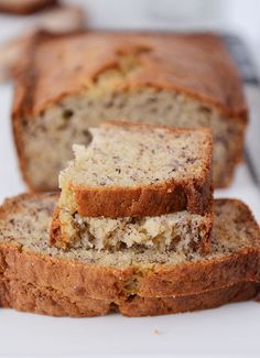 slices of banana bread sitting on top of a white cutting board next to a knife