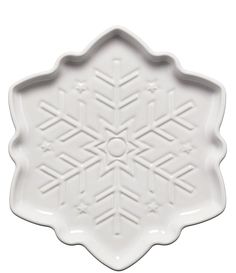 a white platter with an intricate design on the front and side, in the shape of a snowflake