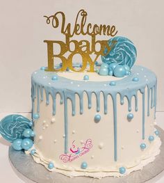 a welcome baby cake with blue and white icing on it's bottom tier