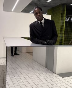 a man in a suit and tie sitting at a table with his hands on his hips