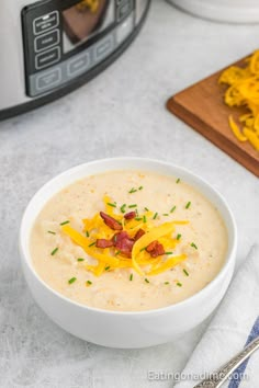 a bowl of soup with cheese and bacon in it next to an instant pressure cooker